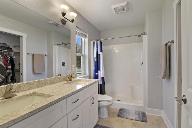 2130 90th St, Sturtevant, WI 53177 - full bathroom featuring a stall shower, double vanity, toilet, and baseboards