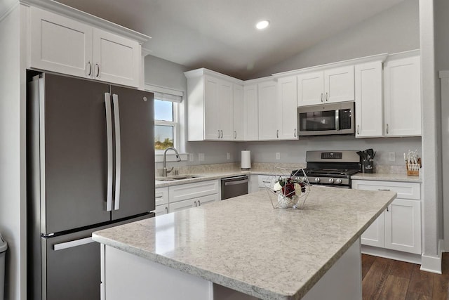 2130 90th St, Sturtevant, WI 53177 - kitchen with appliances with stainless steel finishes, a sink, lofted ceiling, white cabinetry, and a center island
