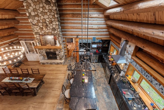 644 County Highway K, Hartford, WI 53027 - living room featuring log walls, wood-type flooring, a fireplace, wooden ceiling, and a skylight