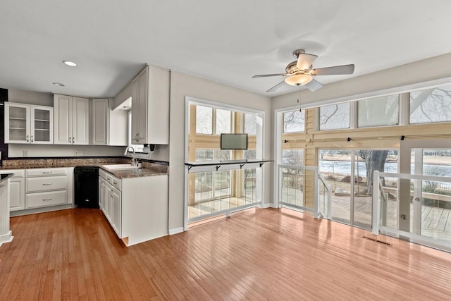 kitchen with black dishwasher, a sink, light wood-style floors, ceiling fan, and recessed lighting