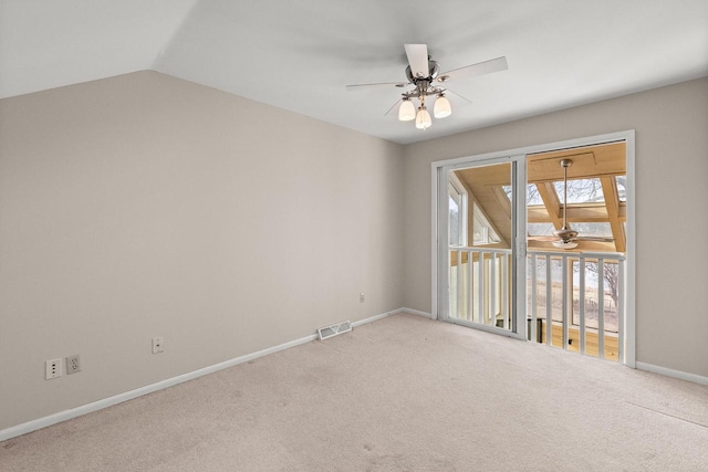 carpeted empty room featuring ceiling fan, baseboards, and vaulted ceiling