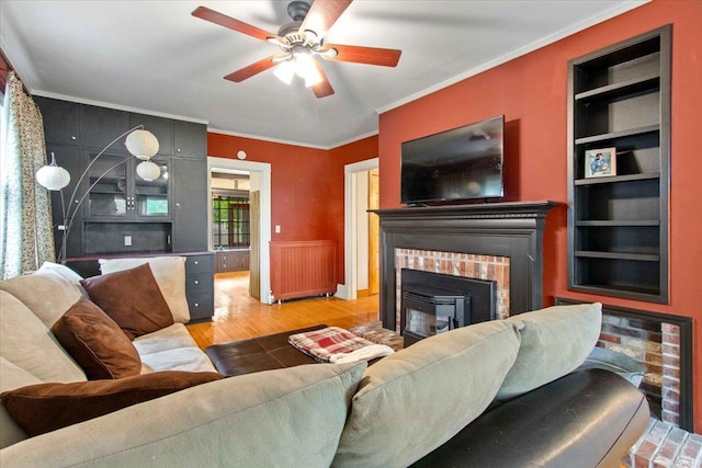 330 1st St, Port Edwards, WI 54469 - living room featuring wood finished floors, crown molding, built in features, a fireplace, and ceiling fan