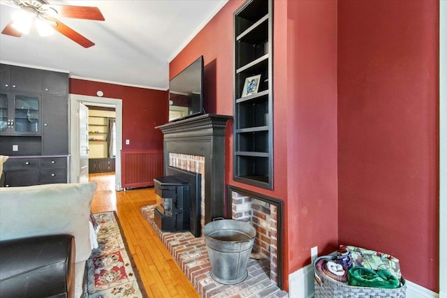 330 1st St, Port Edwards, WI 54469 - living room featuring ornamental molding, wood-type flooring, ceiling fan, and a wood stove