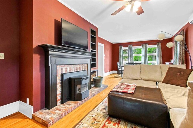 330 1st St, Port Edwards, WI 54469 - living area featuring ceiling fan, wood finished floors, a wood stove, ornamental molding, and baseboards