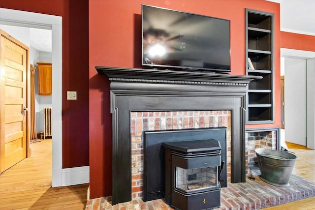 330 1st St, Port Edwards, WI 54469 - detailed view of radiator heating unit, baseboards, wood finished floors, and a brick fireplace