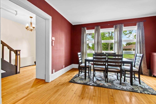 330 1st St, Port Edwards, WI 54469 - dining area featuring radiator heating unit, a chandelier, hardwood / wood-style flooring, stairway, and ornamental molding