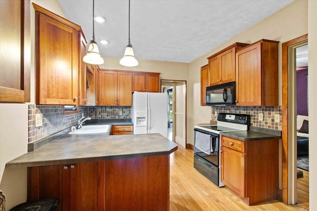 330 1st St, Port Edwards, WI 54469 - kitchen featuring black appliances, a sink, dark countertops, a peninsula, and tasteful backsplash