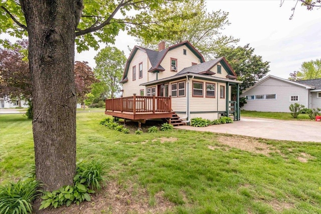 330 1st St, Port Edwards, WI 54469 - view of front of house featuring a gambrel roof, a wooden deck, a chimney, roof with shingles, and a front yard
