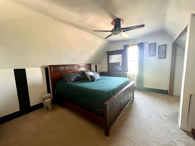 bedroom with vaulted ceiling, light colored carpet, ceiling fan, and baseboards