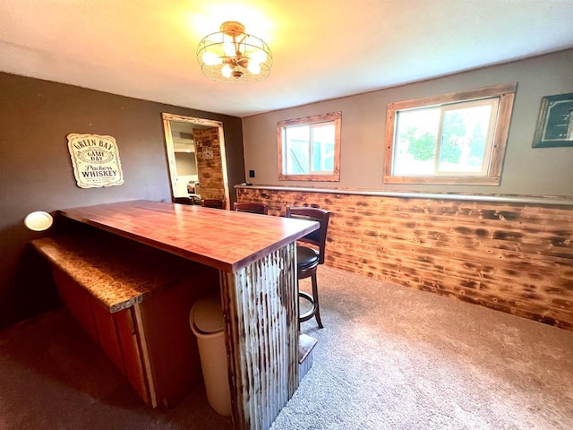 carpeted dining area featuring wainscoting
