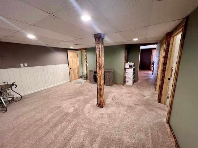 finished basement with carpet flooring, a drop ceiling, a wainscoted wall, and recessed lighting