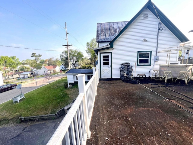 view of side of home with a standing seam roof, fence, and metal roof