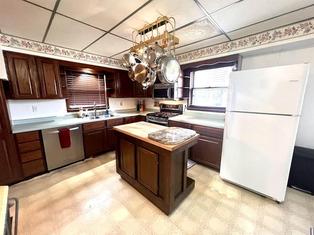 kitchen with open shelves, stainless steel appliances, a sink, light flooring, and butcher block counters