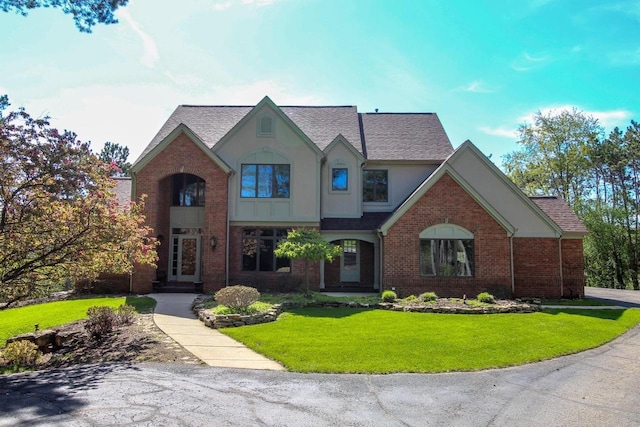 W8849 Deer Run Trl, Cambridge, WI 53523 - view of front facade with a front yard, brick siding, stucco siding, and roof with shingles