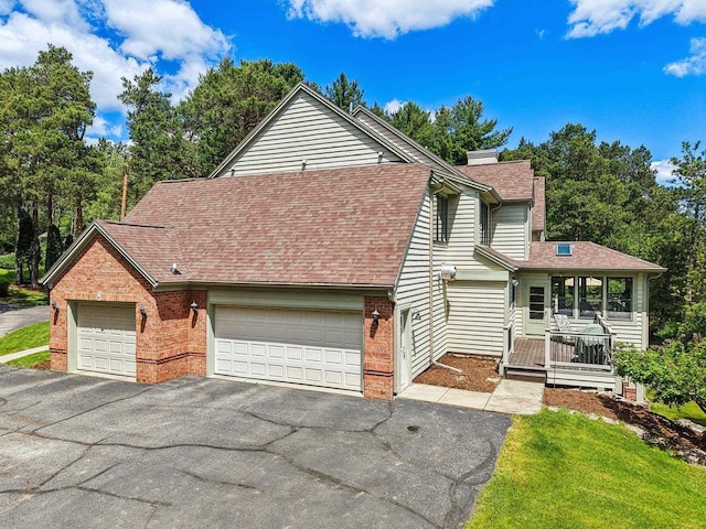 W8849 Deer Run Trl, Cambridge, WI 53523 - view of front of home featuring a chimney, brick siding, roof with shingles, and driveway