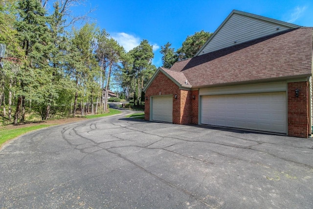 W8849 Deer Run Trl, Cambridge, WI 53523 - view of side of property with brick siding, a shingled roof, and driveway