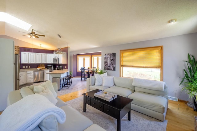 1502 Marquardt Rd, Wausau, WI 54403 - living room featuring a skylight, a ceiling fan, light wood finished floors, and lofted ceiling