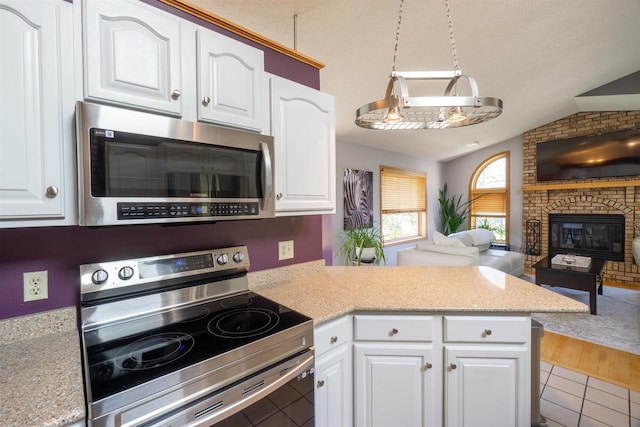 1502 Marquardt Rd, Wausau, WI 54403 - kitchen featuring stainless steel appliances, open floor plan, vaulted ceiling, a peninsula, and white cabinets