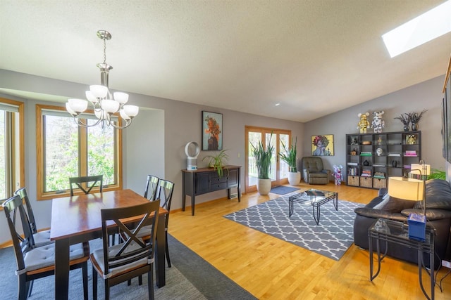 1502 Marquardt Rd, Wausau, WI 54403 - dining area featuring a chandelier, wood finished floors, lofted ceiling, a skylight, and baseboards