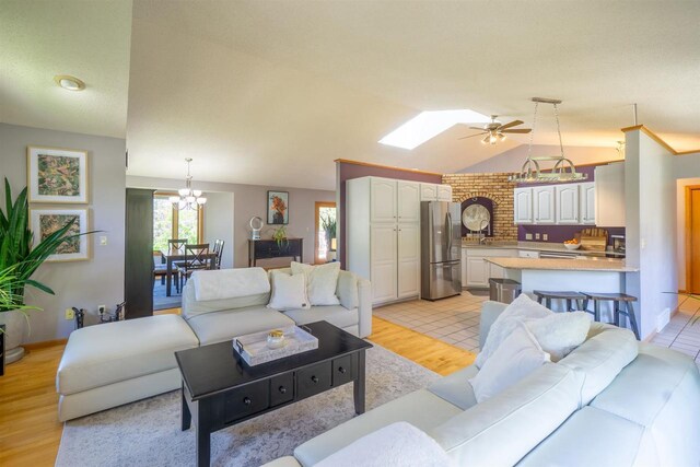 1502 Marquardt Rd, Wausau, WI 54403 - living room with ceiling fan, a chandelier, lofted ceiling, light wood-type flooring, and a skylight