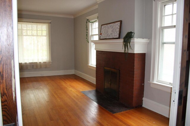 2909 N Farwell Ave, Milwaukee, WI 53211 - unfurnished living room featuring a brick fireplace, baseboards, wood finished floors, and crown molding