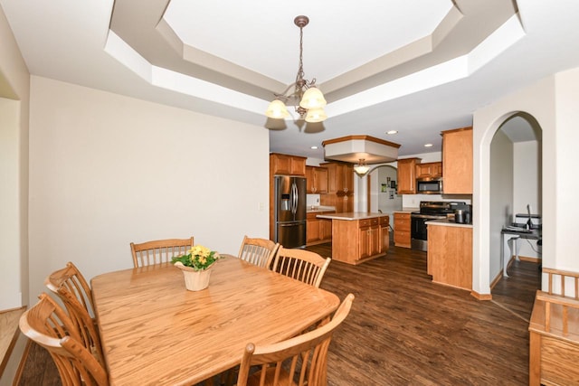 6454 Heritage Ave, Mount Pleasant, WI 53406 - dining space with arched walkways, a chandelier, a tray ceiling, dark wood finished floors, and recessed lighting
