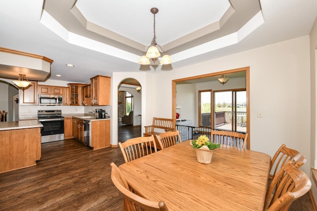6454 Heritage Ave, Mount Pleasant, WI 53406 - dining area featuring arched walkways, dark wood-style flooring, a raised ceiling, and recessed lighting