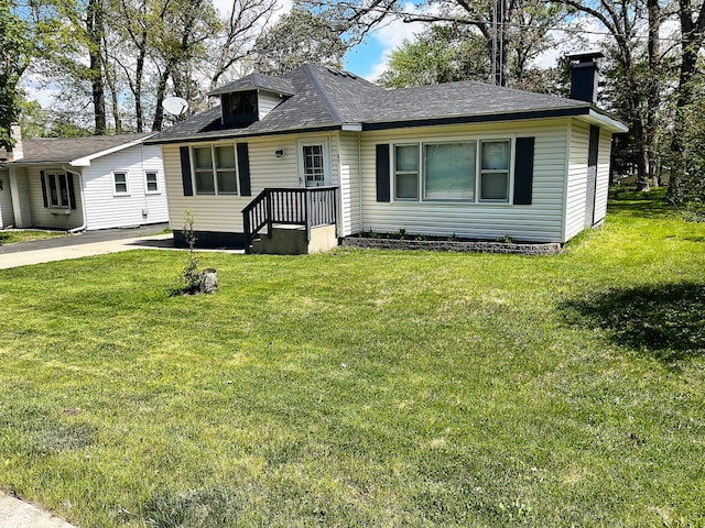 91 Oakwood St, Williams Bay, WI 53191 - view of front of house with a chimney, a front yard, and a shingled roof