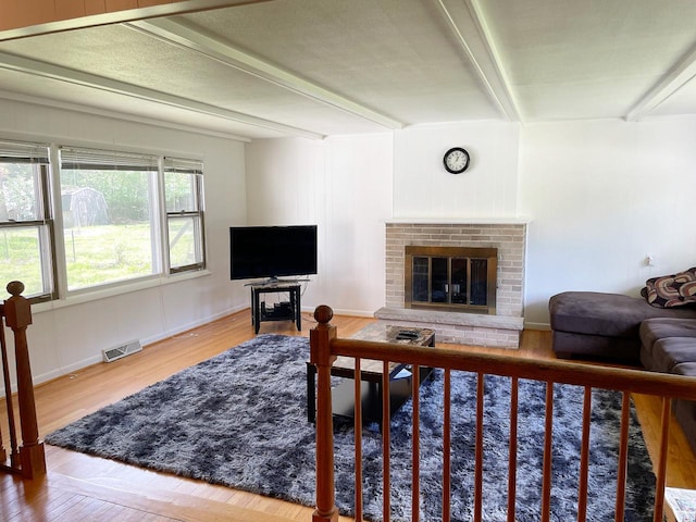91 Oakwood St, Williams Bay, WI 53191 - living area featuring beamed ceiling, a brick fireplace, wood finished floors, and baseboards