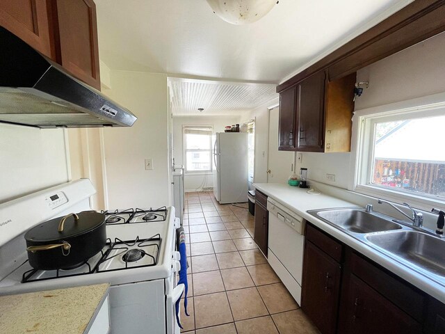 91 Oakwood St, Williams Bay, WI 53191 - kitchen with white appliances, under cabinet range hood, light countertops, light tile patterned flooring, and dark brown cabinets