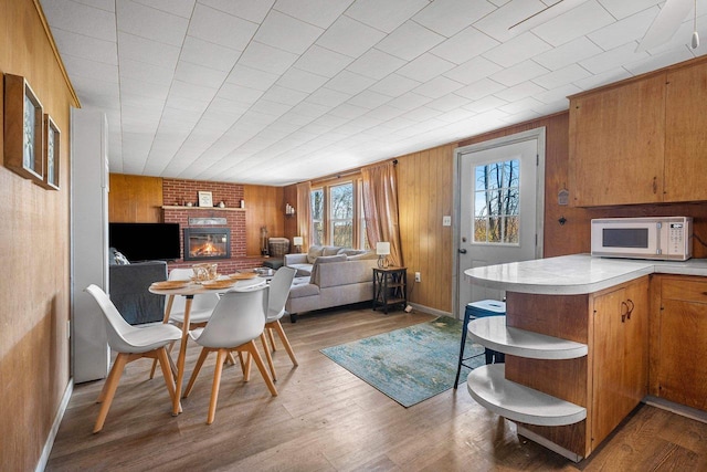 229 Bay Rd, Peshtigo, WI 54147 - dining space featuring a fireplace, wood finished floors, wooden walls, and baseboards