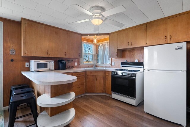 229 Bay Rd, Peshtigo, WI 54147 - kitchen with white appliances, a sink, a peninsula, light countertops, and a ceiling fan