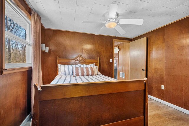 229 Bay Rd, Peshtigo, WI 54147 - bedroom with wood walls, wood finished floors, and a ceiling fan