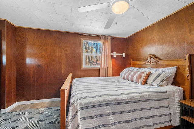 229 Bay Rd, Peshtigo, WI 54147 - bedroom with wooden walls, wood finished floors, ceiling fan, and baseboards