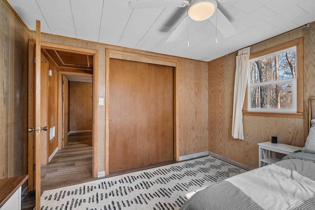 229 Bay Rd, Peshtigo, WI 54147 - bedroom with wooden walls, baseboards, a closet, wood finished floors, and ceiling fan