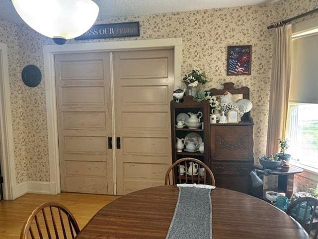 110 Hewett St, Neillsville, WI 54456 - dining space featuring wallpapered walls, light wood-style floors, and baseboards
