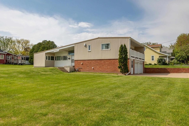 30 Elmer St, Platteville, WI 53818 - back of house with brick siding, concrete driveway, a garage, and a lawn