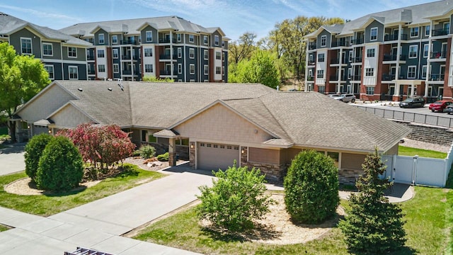 2149 Abbey Rd Unit 2147-2145, Onalaska, WI 54650 - view of front of property with fence, stone siding, an attached garage, concrete driveway, and a gate