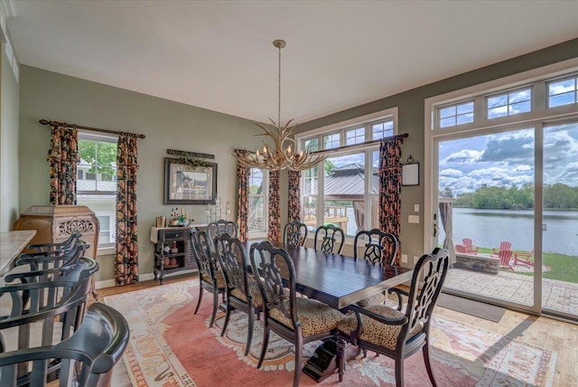 W11601 Demynck Rd, Lodi, WI 53555 - dining room featuring a chandelier, light wood-style flooring, plenty of natural light, and a water view