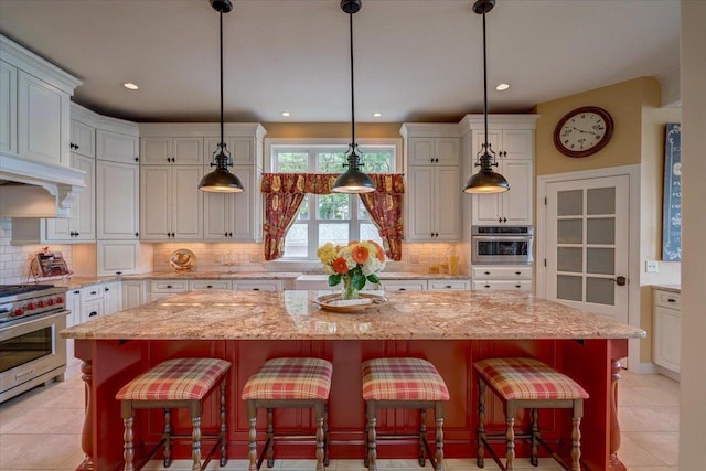 W11601 Demynck Rd, Lodi, WI 53555 - kitchen featuring stainless steel appliances, white cabinets, light tile patterned floors, decorative backsplash, and recessed lighting