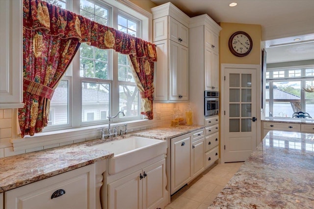W11601 Demynck Rd, Lodi, WI 53555 - kitchen with a sink, healthy amount of natural light, decorative backsplash, and light stone counters