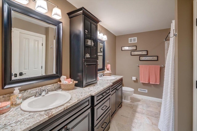 W11601 Demynck Rd, Lodi, WI 53555 - bathroom featuring double vanity, baseboards, and toilet