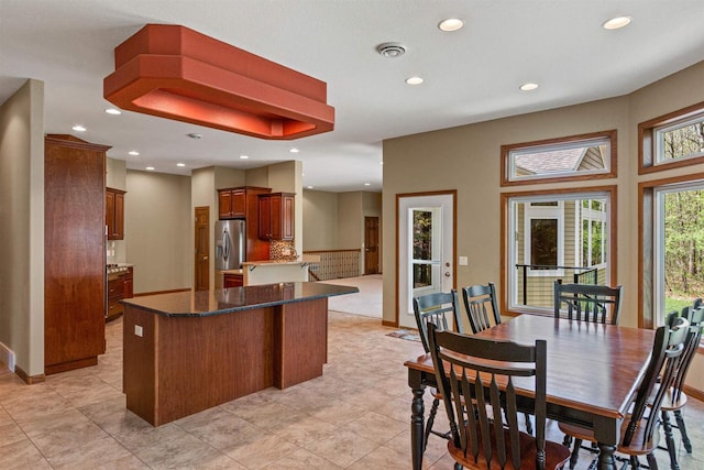 6056 Sharonwood Ln, Stevens Point, WI 54482 - kitchen featuring stainless steel fridge, recessed lighting, a kitchen island, tasteful backsplash, and light tile patterned floors
