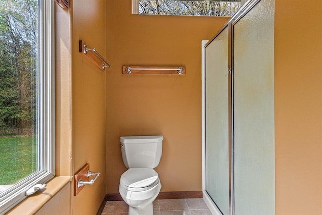 6056 Sharonwood Ln, Stevens Point, WI 54482 - bathroom featuring toilet, a shower with door, healthy amount of natural light, and tile patterned flooring
