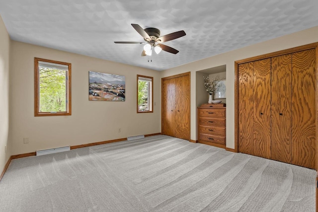 unfurnished bedroom with multiple windows, multiple closets, baseboards, and carpet floors