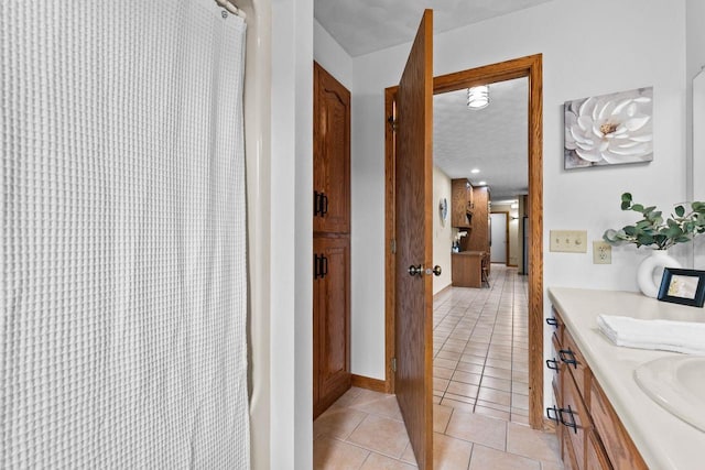 full bathroom featuring tile patterned flooring, vanity, baseboards, and curtained shower