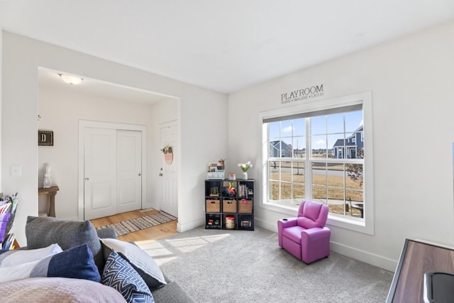 living area with baseboards and carpet