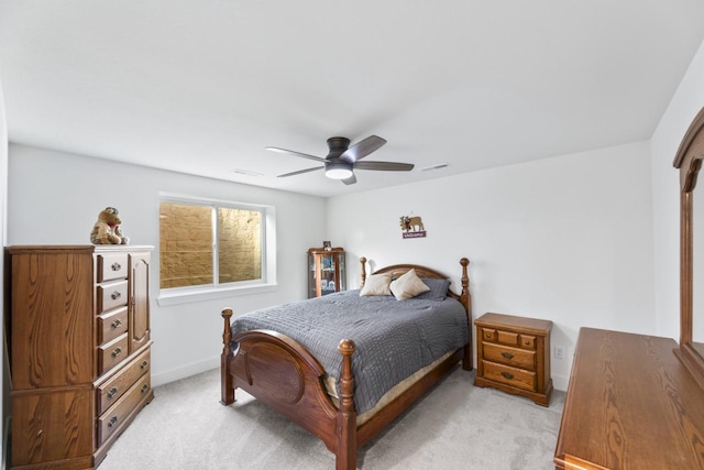 bedroom with light colored carpet, a ceiling fan, and baseboards