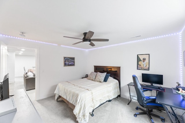 bedroom featuring light carpet, a desk, ceiling fan, and baseboards