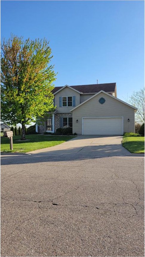 416 Rimrock Rd, Janesville, WI 53548 - view of front facade with driveway, an attached garage, and a front lawn